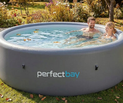 Aufblasbarer Pool im Herbst steht auf einem Rasen, ein Mann und eine Frau im Wasser