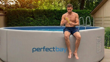Ein Mann sitzt am Rande eines Pools und hält in der Hand ein Poolthermometer