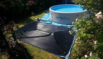 Auf dem Rasen ausgebreitete Poolheizung Gartepool