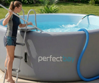 Eine Frau steht bei einem Gartenpool und versucht Poolwasser zu wechseln